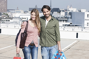 Deutschland, Köln, Junges Paar mit Einkaufstüten, lächelnd, Porträt - FMKF000393