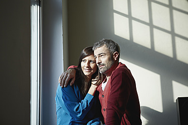 Germany, Cologne, Couple sitting at window, smiling - RHF000070