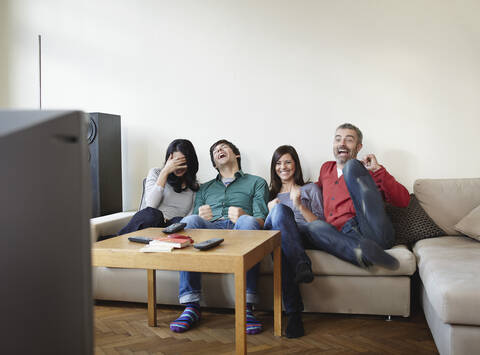 Deutschland, Köln, Mann und Frau sehen fern, lächelnd, lizenzfreies Stockfoto