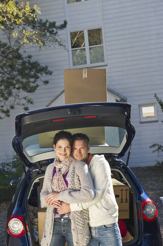 Deutschland, Bayern, Gröbenzell, Pärchen stehend neben Auto, lächelnd, Porträt, lizenzfreies Stockfoto