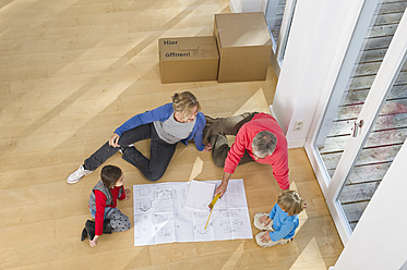 Germany, Bavaria, Grobenzell, Family looking at blueprint in house - WESTF018215