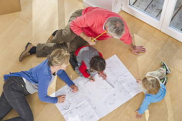 Germany, Bavaria, Grobenzell, Family looking at blueprint in house - WESTF018219