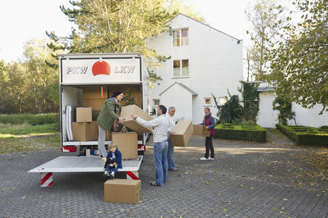 Germany, Bavaria, Grobenzell, Family loading boxes into truck for moving house stock photo