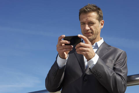 Deutschland, Bayern, München, Geschäftsmann mit Mobiltelefon, lizenzfreies Stockfoto