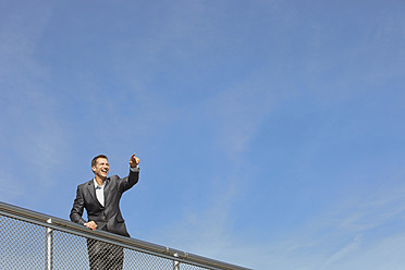 Germany, Bavaria, Munich, Businessman standing near railings, smiling - SKF000715