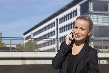 Germany, Bavaria, Munich, Businesswoman talking on phone, smiling - SKF000725