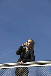 Germany, Bavaria, Munich, Businesswoman talking on phone, smiling - SKF000728