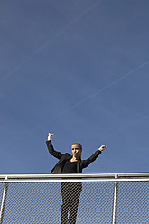 Germany, Bavaria, Munich, Businesswoman showing victory sign - SKF000729