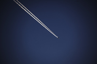 Deutschland, Kondensstreifen eines Flugzeugs am blauen Himmel - TLF000627