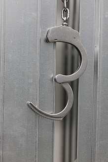 Handcuffs attached to metal door, close up - HSTF000017