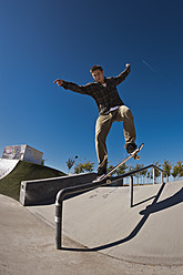 Germany, North Rhine-Westphalia, Duisburg, Skateboarder performing trick on ramp at skateboard park - KJF000160