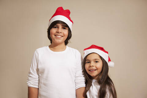 Kinder mit Weihnachtsmannmütze, lächelnd, Porträt, lizenzfreies Stockfoto