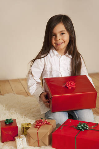 Mädchen mit Weihnachtsgeschenk, lächelnd, Porträt, lizenzfreies Stockfoto