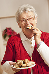 Ältere Frau isst Weihnachtsplätzchen, Porträt - RIMF000098