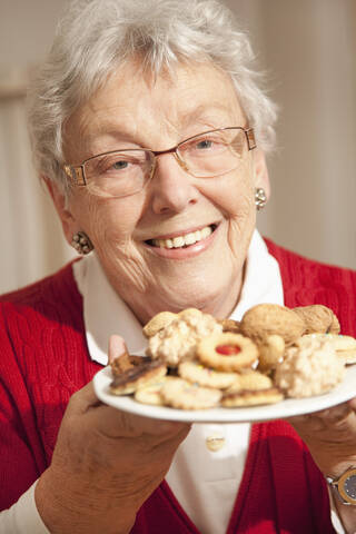 Ältere Frau mit Weihnachtsgebäck, lächelnd, Porträt, lizenzfreies Stockfoto