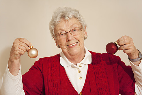 Ältere Frau mit Weihnachtskugeln, lächelnd, Porträt - RIMF000102