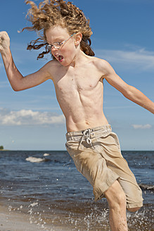 Sweden, Boy running on beach near Borrby - SHF000568