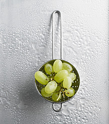 Grapes in colander on white background - KSWF000772