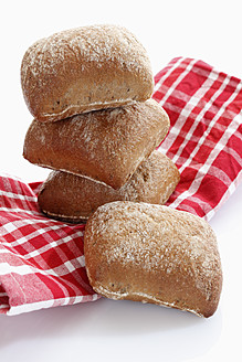 Stapel von Brot mit Küchentuch auf weißem Hintergrund - CSF015554