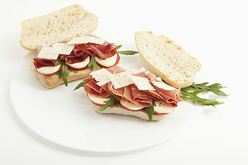 Panini mit Schinken, Tomaten, Mozzarella, Rucola und italienischem Käse im Teller - MAEF004041