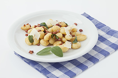 Gnocchi und Speck mit Serviette auf weißem Hintergrund - MAEF004060