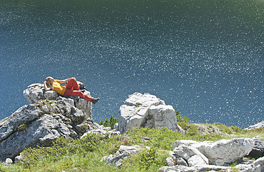 Austria, Salzburg, Hiker lying on rock - HHF003771