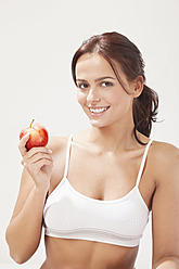 Junge Frau mit Apfel, lächelnd, Porträt - MAEF004105