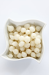 Silberhäutige Zwiebeln in Schale auf weißem Hintergrund - CSF015641