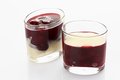 Glas mit roter Grütze und Vanillesoße auf weißem Hintergrund - CSF015647