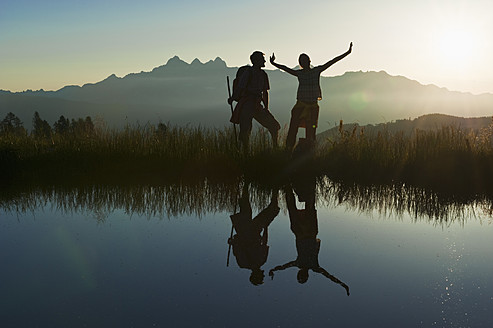 Austria, Salzburg, Couple having fun at alpine lake - HHF003778