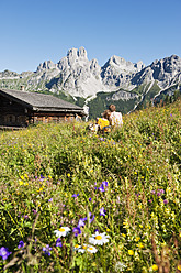 Österreich, Salzburg, Filzmoos, Pärchen sitzend und ruhend auf Almwiese - HHF003818