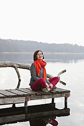 Deutschland, Berlin, Wandlitz, Mittlere erwachsene Frau auf Steg sitzend, Porträt - WESTF018288