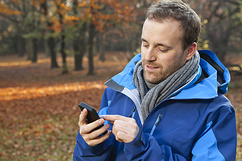 Deutschland, Berlin, Wandlitz, Mittlerer Erwachsener Mann mit Mobiltelefon - WESTF018298