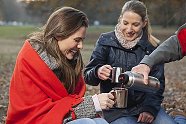 Germany, Berlin, Wandlitz, Friends drinking hot beverage, smiling - WESTF018311