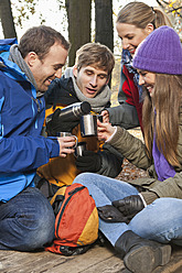 Deutschland, Berlin, Wandlitz, Freunde trinken Heißgetränk, lächelnd - WESTF018314