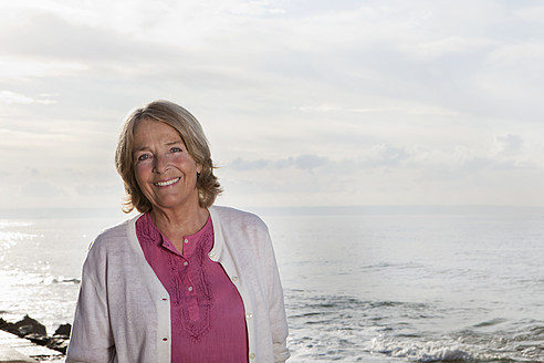 Spain, Mallorca, Senior woman standing at sea shore, smiling, portrait - SKF000765