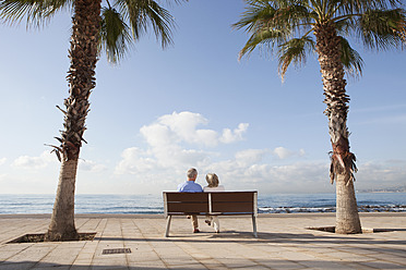 Spanien, Mallorca, Älteres Paar sitzt auf Bank am Meer - SKF000801