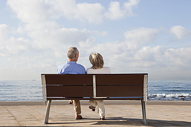 Spanien, Mallorca, Älteres Paar sitzt auf Bank am Meer - SKF000804