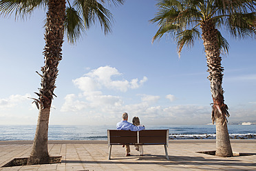 Spanien, Mallorca, Älteres Paar sitzt auf Bank am Meer - SKF000805