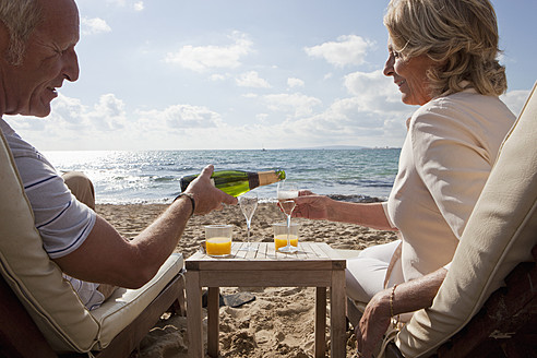 Spanien, Mallorca, Älteres Paar trinkt Sekt am Strand - SKF000855