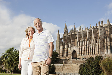 Spanien, Mallorca, Palma, Senior Paar lächelnd mit Kathedrale Santa Maria, Portrait - SKF000861