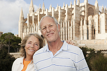 Spanien, Mallorca, Palma, Senior Paar lächelnd mit Kathedrale Santa Maria, Portrait - SKF000862