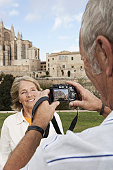 Spanien, Mallorca, Palma, Älteres Paar lächelnd fotografiert mit Kathedrale Santa Maria - SKF000870