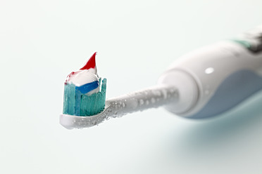 Elektrische Zahnbürste mit Zahnpasta auf weißem Hintergrund - CSF015714
