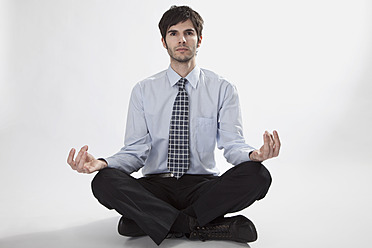 Businessman doing meditation, portrait - MAEF004203