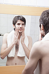 Junger Mann betrachtet sein Spiegelbild - MAEF004223