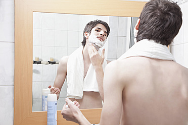 Junger Mann trägt im Badezimmer Rasierschaum auf - MAEF004225
