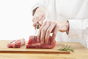 Man cutting meat on chopping board - MAEF004175