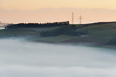 Deutschland, Blick auf eine neblige Landschaft mit Masten und Schweizer Alpen im Hintergrund - SHF000638