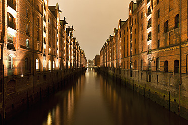 Deutschland, Hamburg, Blick auf die Speicherstadt mit Elbe bei Nacht - FO003800